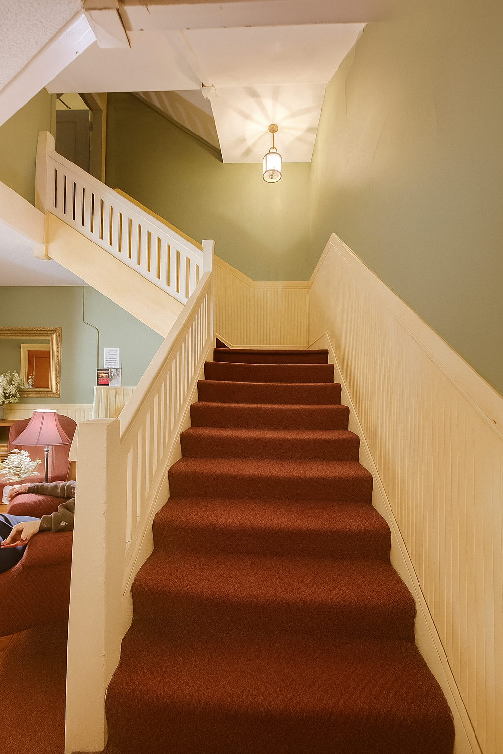 A staircase with a red carpet and a white railing