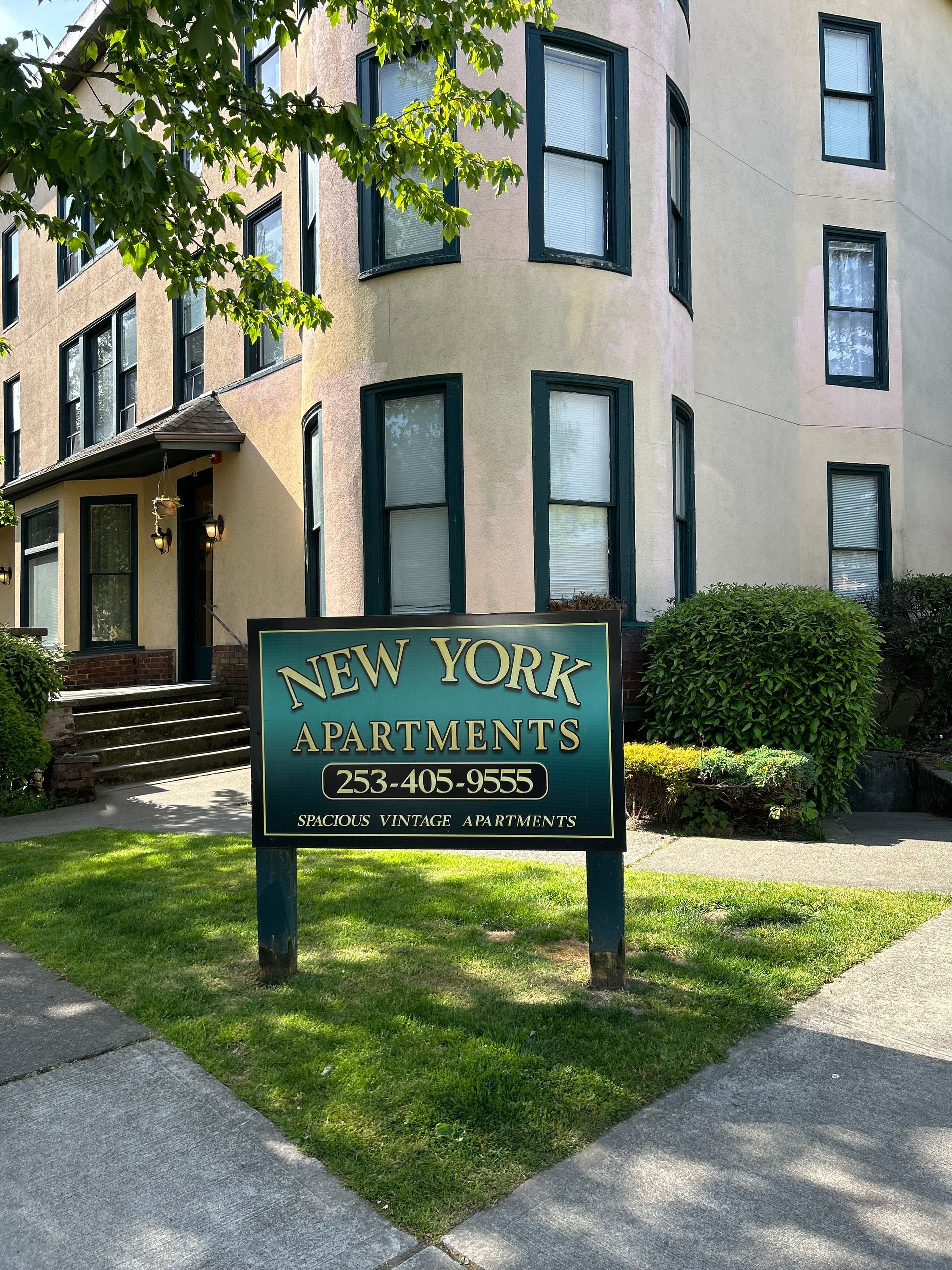 A sign for new york apartments is in front of a building.
