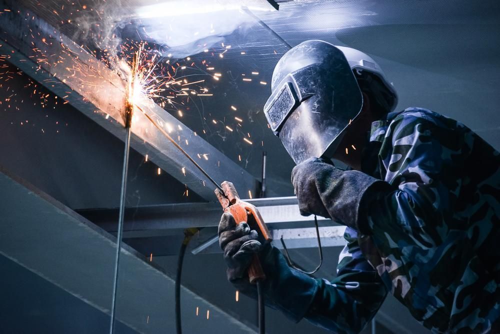 Welder In Protective Gear Working With Sparks In An Indoor Setting — Sheetmetal Improvements & Design in Burleigh Heads, QLD