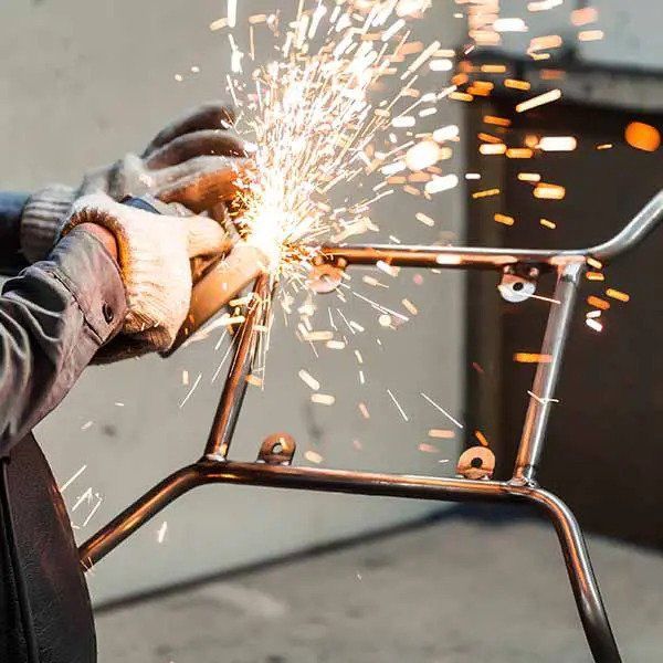 Person Welding Metal Frame, Sparks Flying— Sheetmetal Improvements & Design in Burleigh Heads, QLD