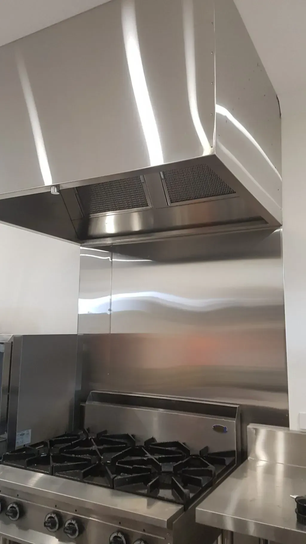 Stainless Steel Commercial Kitchen Range Hood Over A Stove — Sheetmetal Improvements & Design in Burleigh Heads, QLD