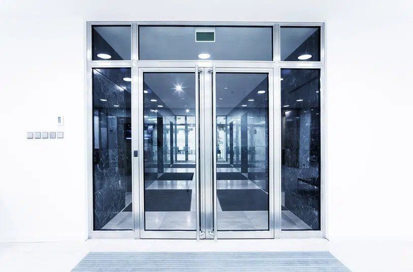Double Glass Doors Framed In Silver Lead Into A Modern Building Hallway — Sheetmetal Improvements & Design in Burleigh Heads, QLD