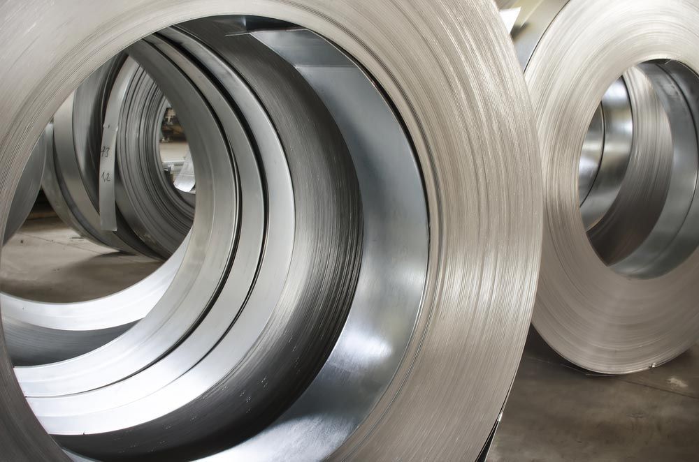 Coils Of Shiny, Rolled Sheet Metal In A Warehouse— Sheetmetal Improvements & Design in Burleigh Heads, QLD