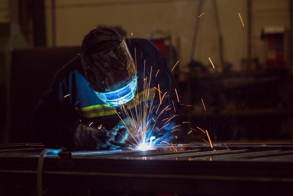 Welder In A Workshop, Sparks Flying as They Join Metal Pieces — Sheetmetal Improvements & Design in Burleigh Heads, QLD