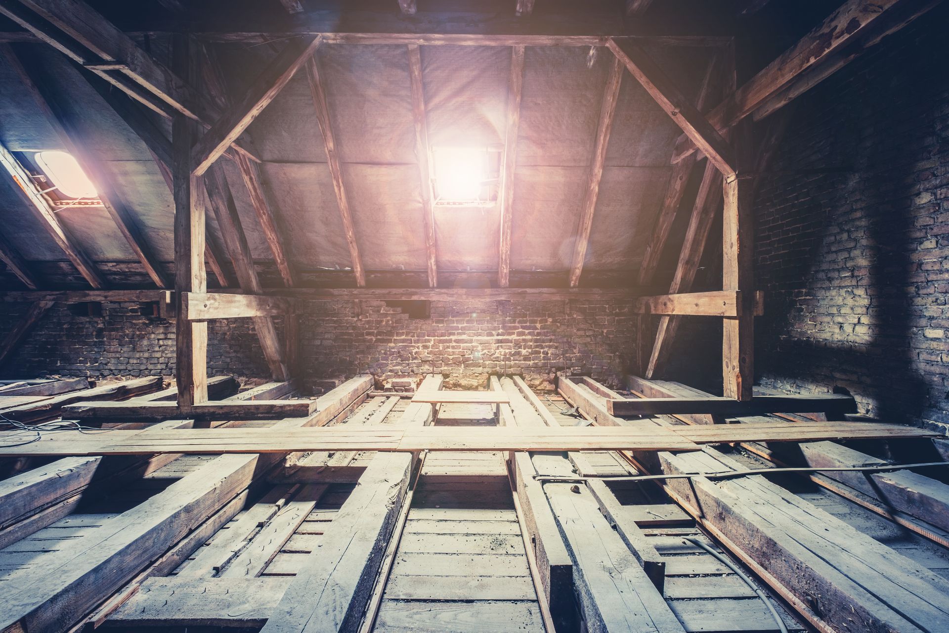 View up an industrial shaft with wooden beams and a bright light overhead