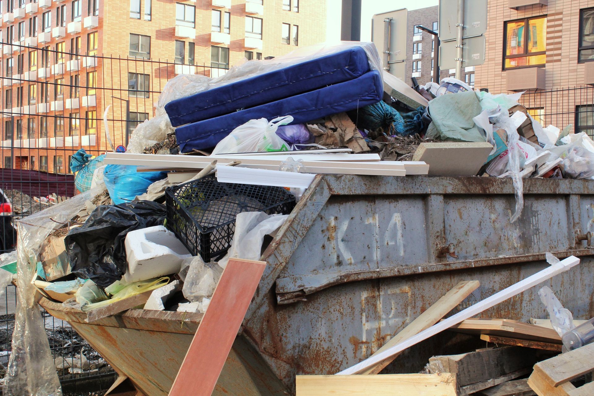 Overflowing dumpster piled with trash and debris in an urban street