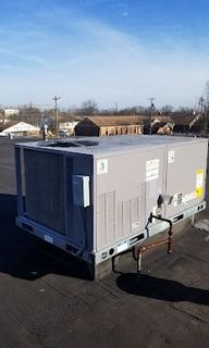 A large air conditioner is sitting on top of a roof.