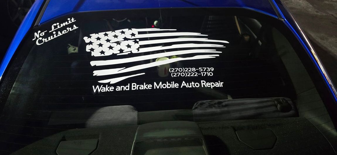 A blue car with a sticker on the windshield that says wake and brake mobile auto repairs