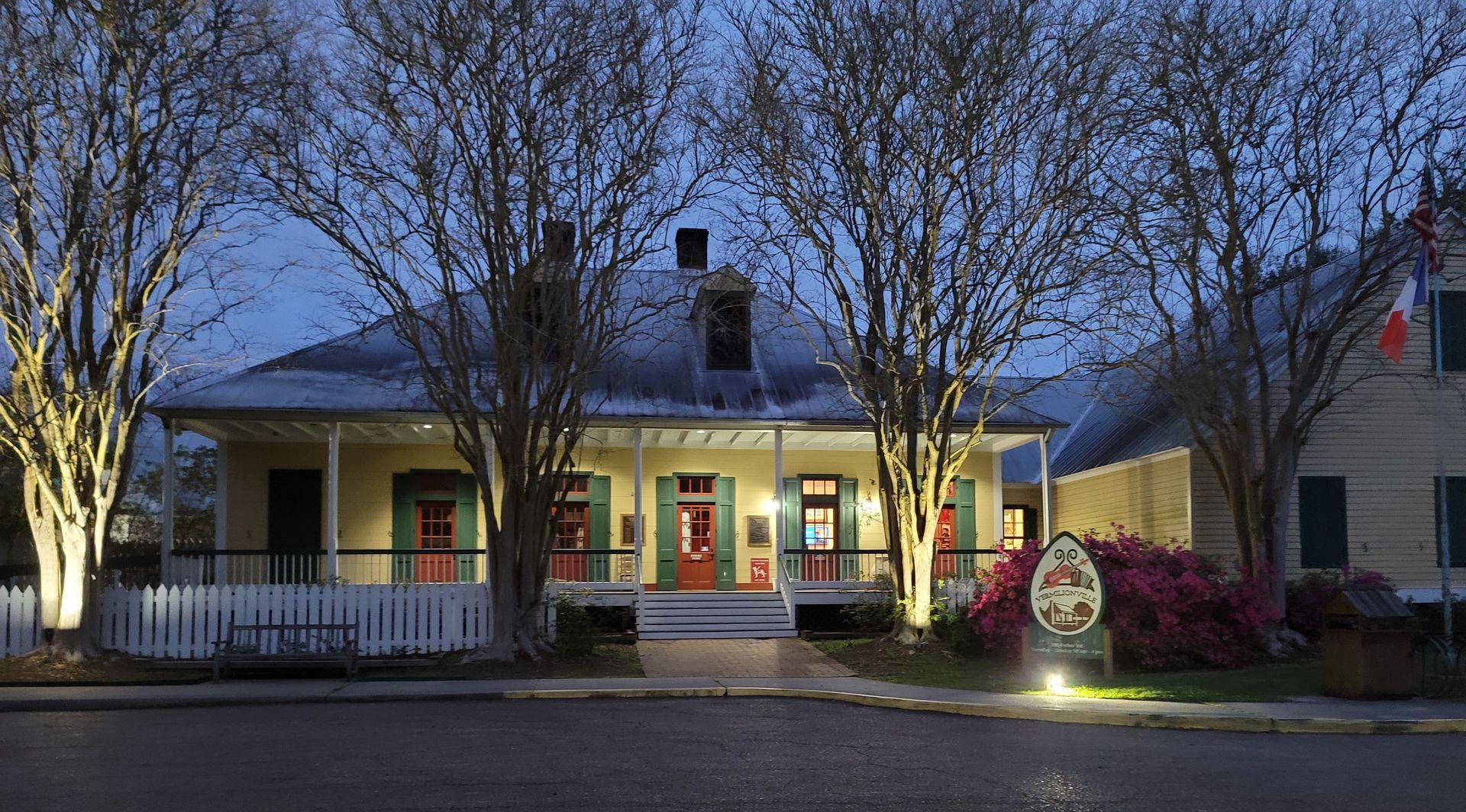 a house with a porch is lit up at night in Vermilionville Louisiana