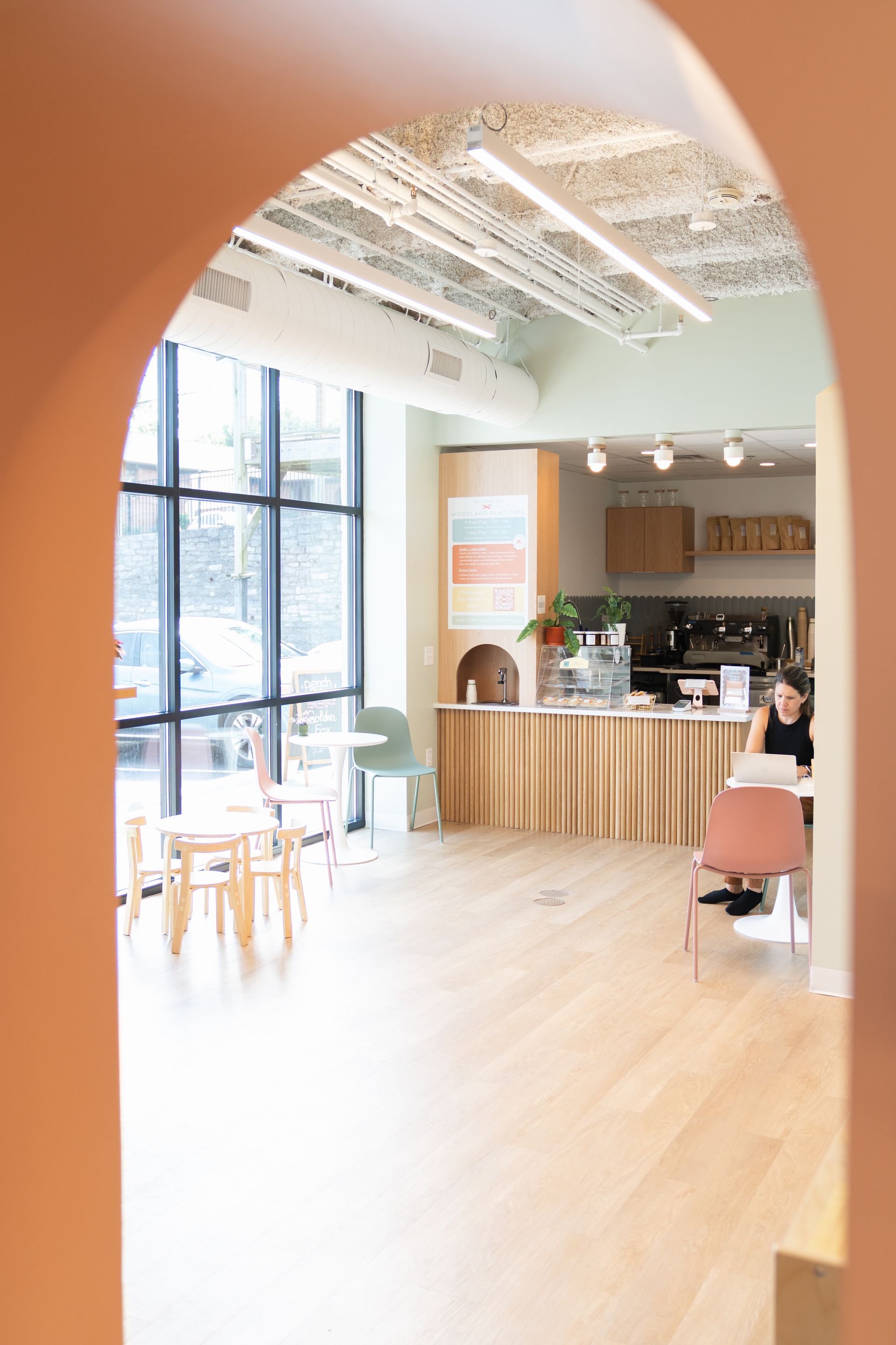 A woman is carrying a child on her shoulders in an orchard.