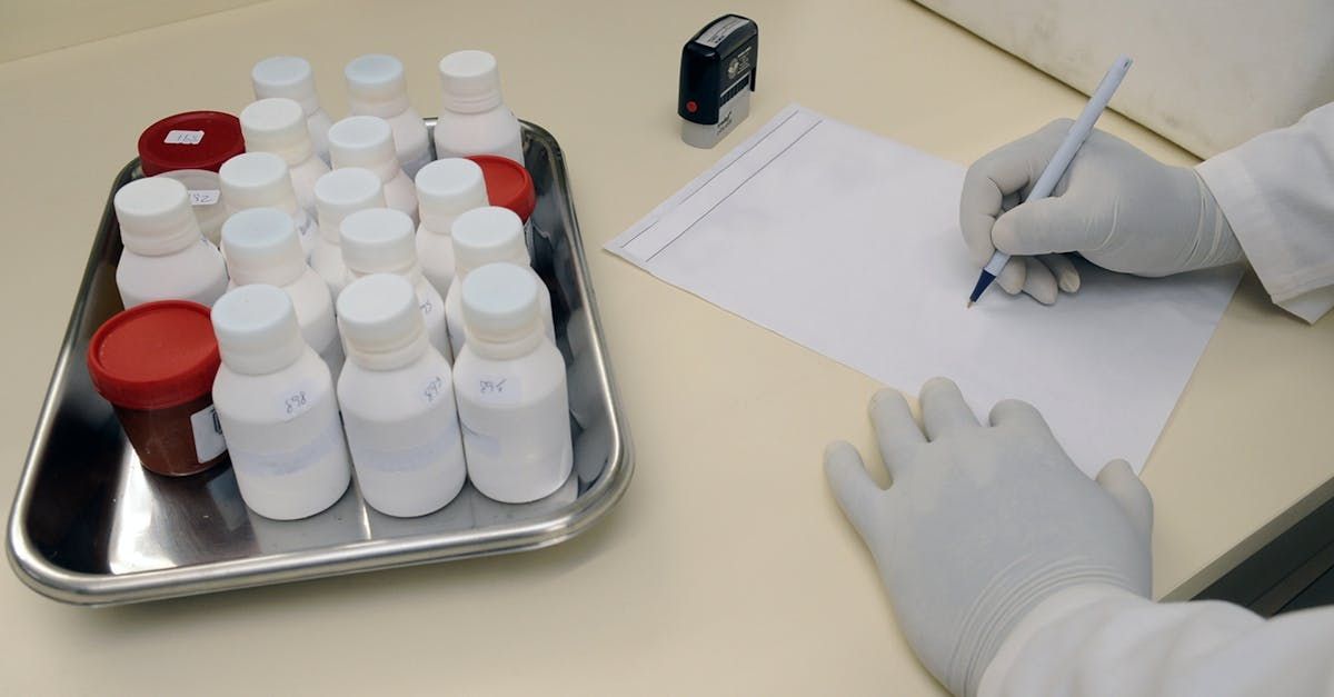 A person is writing on a piece of paper in front of a tray of bottles