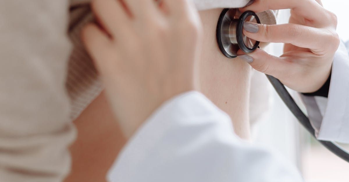 A doctor is using a stethoscope to listen to a patient 's heartbeat.