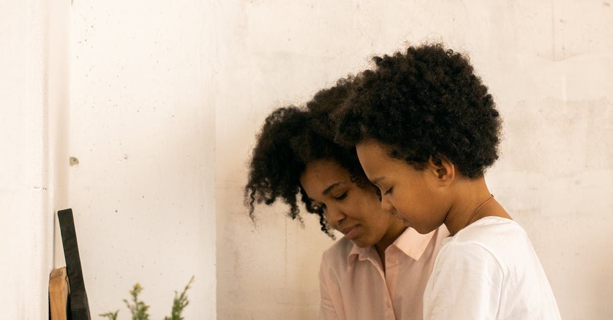 Two women are looking at their reflection in a mirror.