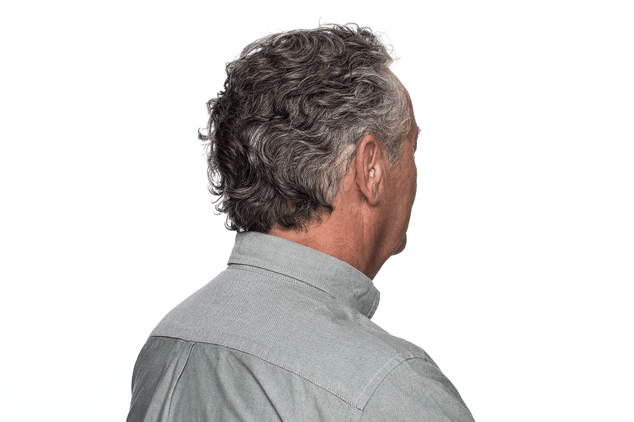 The back of a man 's head with curly hair is shown.