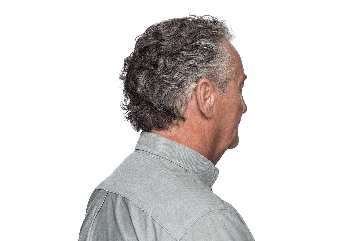 The back of a man wearing a hearing aid.