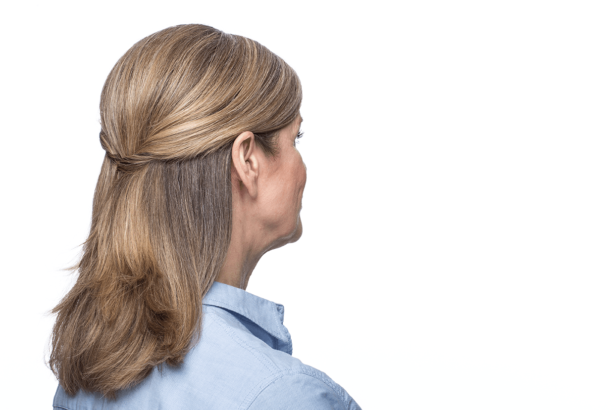 A woman wearing a hearing aid is looking to the side.