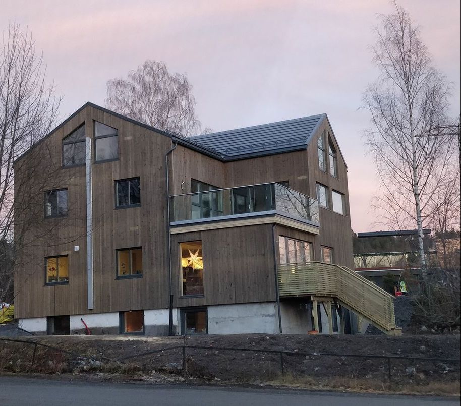 Et stort trehus med balkong og trapper