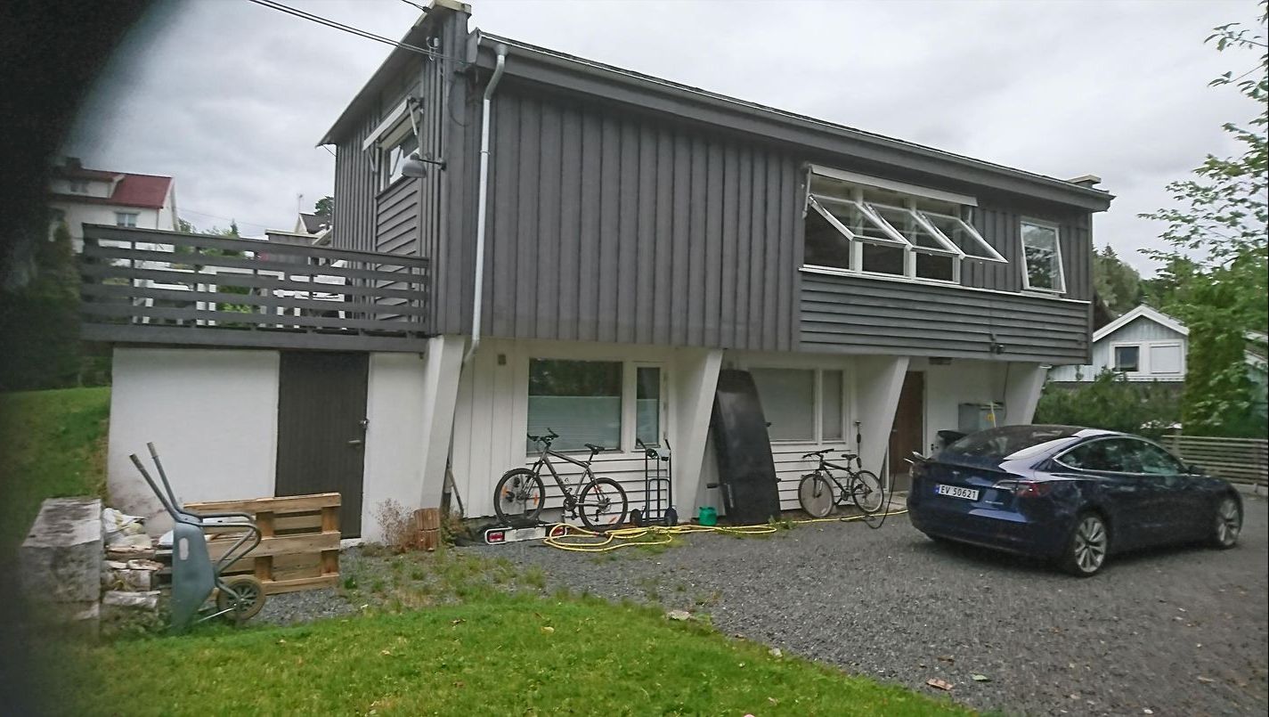 Et hus med en bil parkert foran det