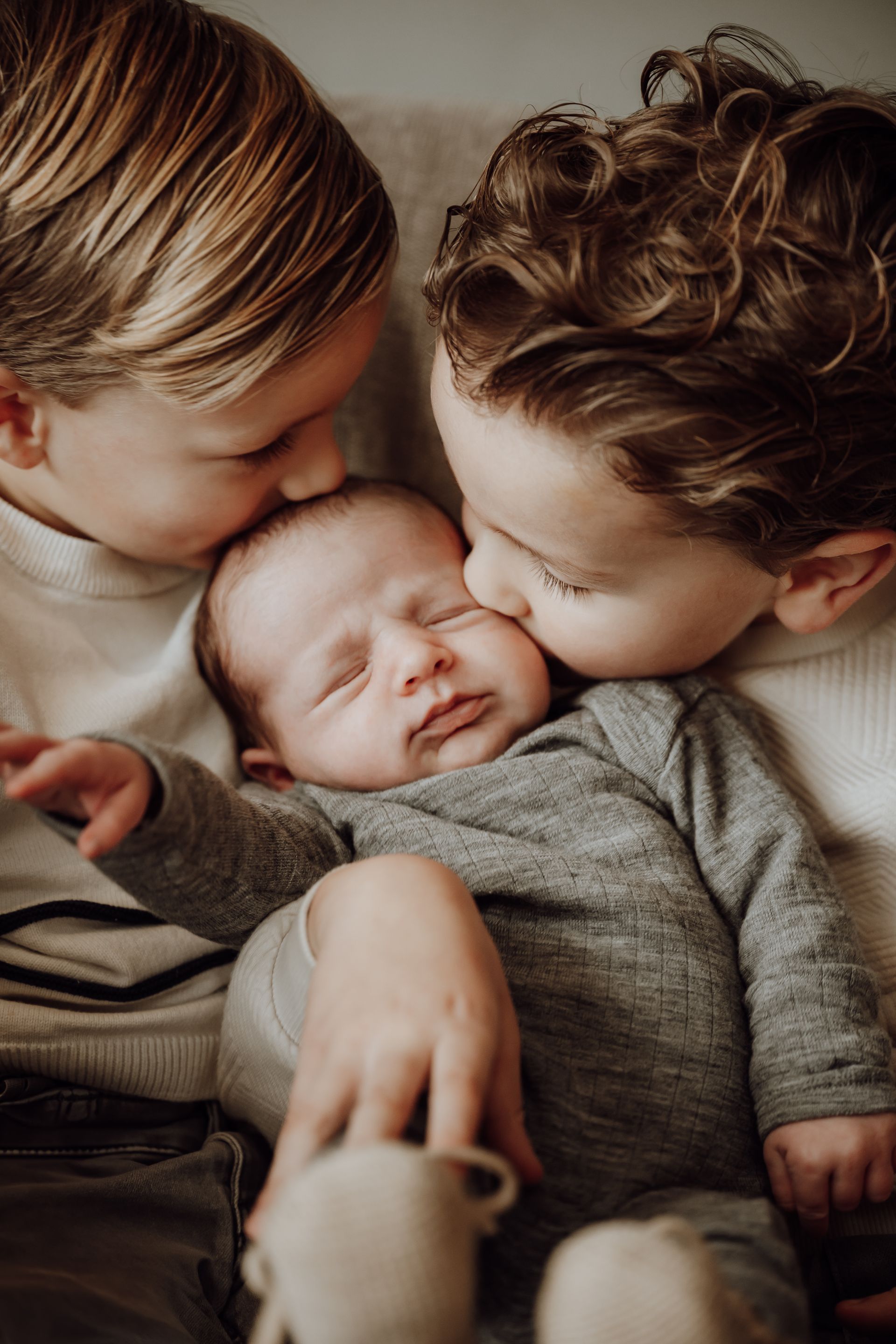 Vrouw wiegt baby in haar armen, neus tegen neus, baby slaapt.
