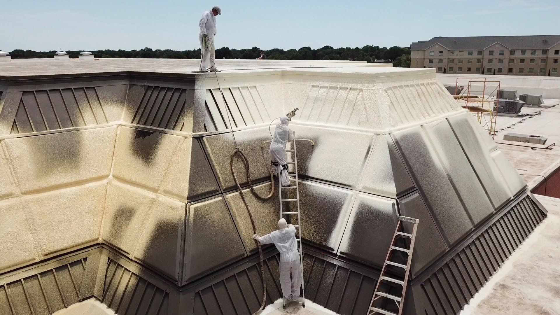 Three Workers Doing a Roof Coating — Burkburnett, TX — Bradley Foam Roofing Three Workers Doing a Roof Coating — Burkburnett, TX — Bradley Foam Roofing