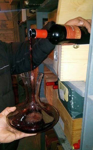 un uomo che versa del vino in un decanter