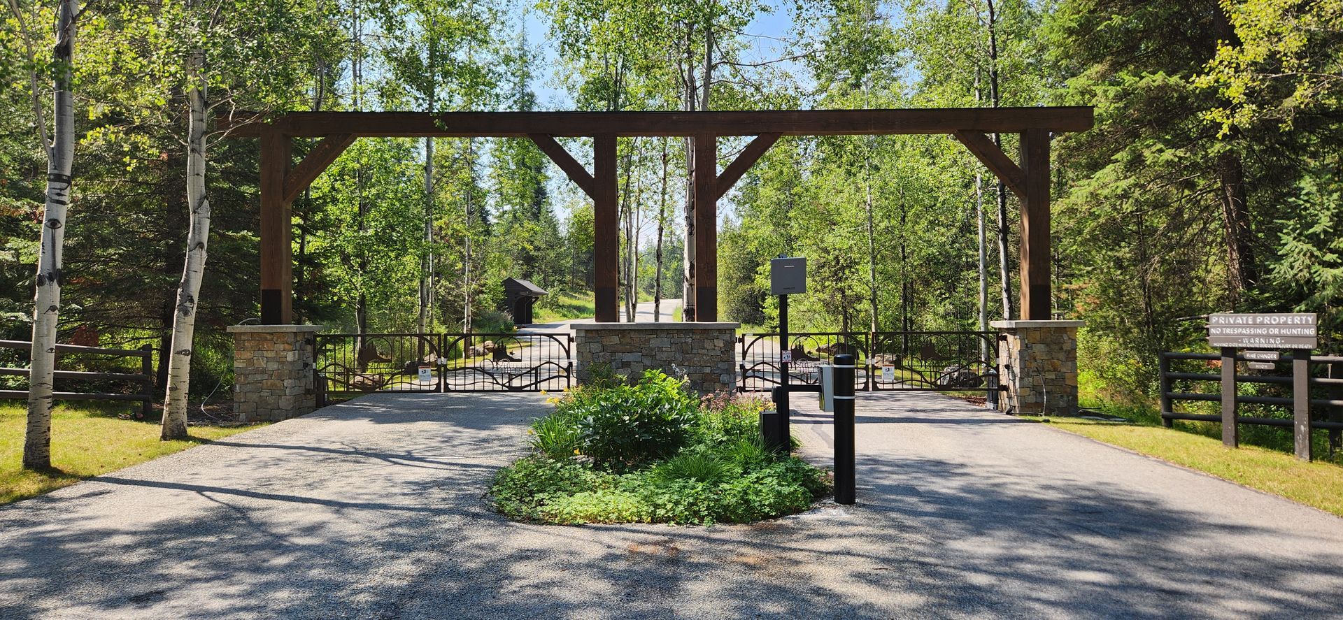 A driveway with a wooden fence and a metal gate