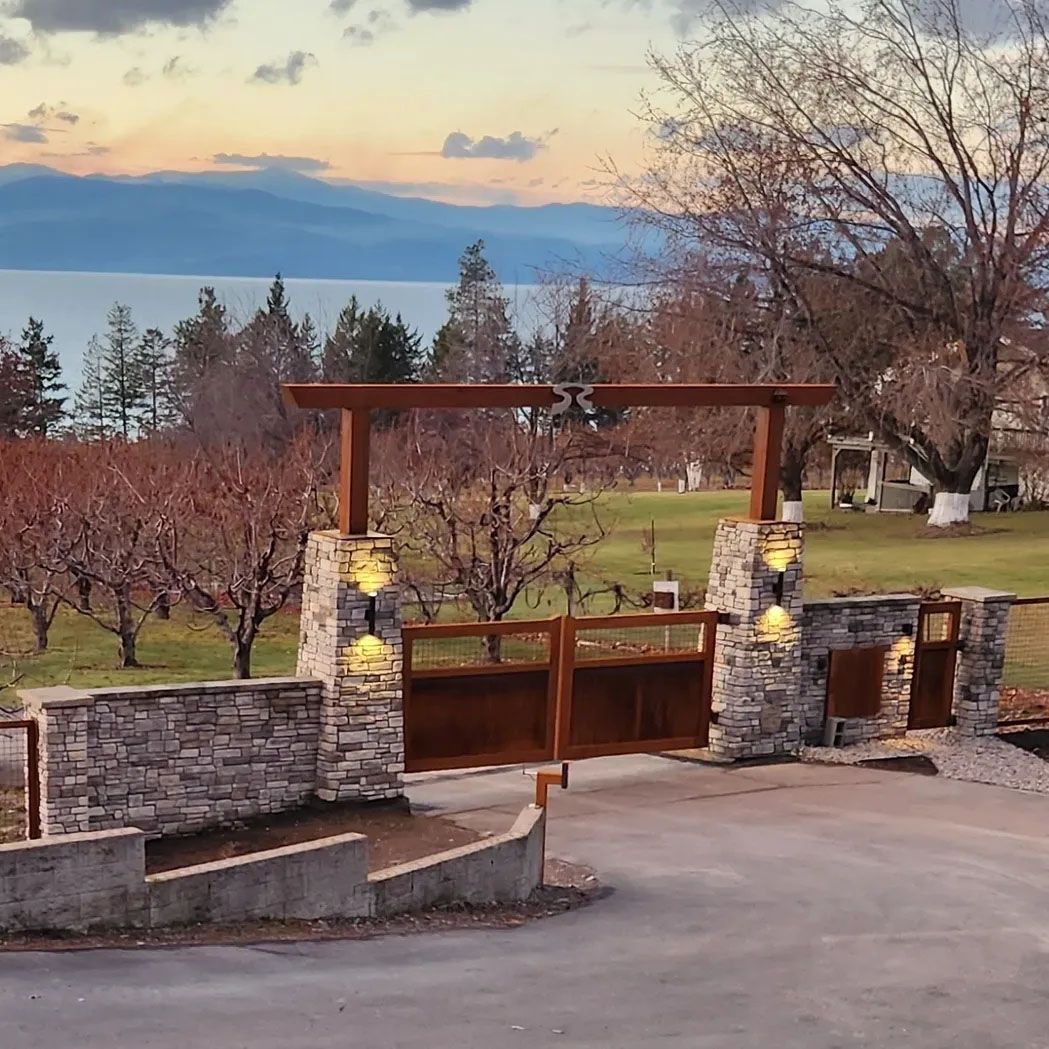 A stone wall with a wooden gate leading to a lake