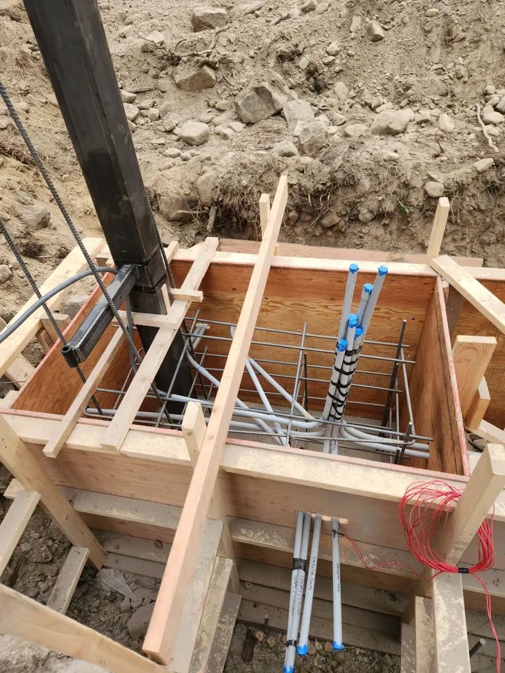 A ladder is sitting in a wooden box on a construction site.