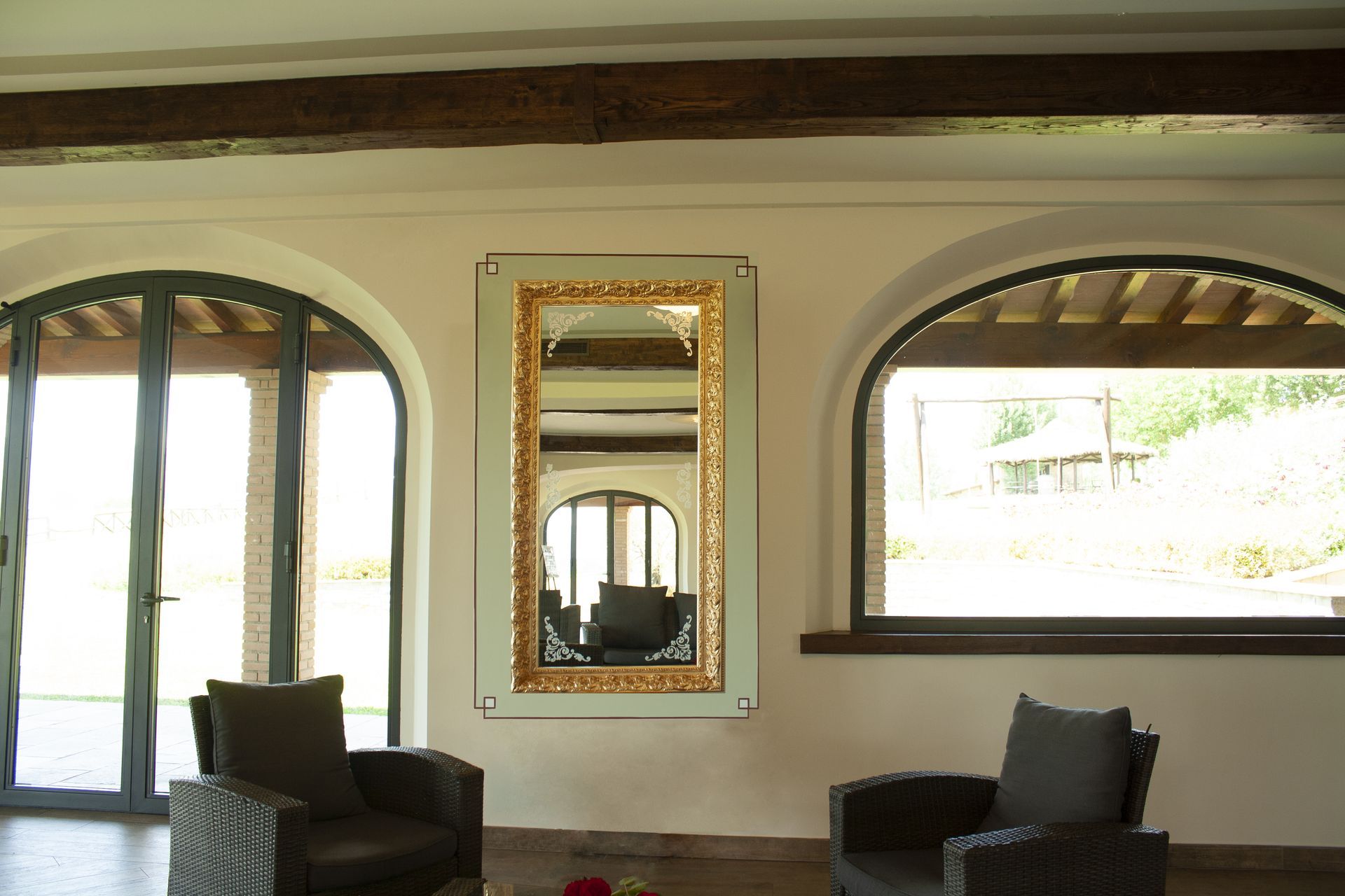 Un soggiorno con due sedie e un grande specchio sul muro