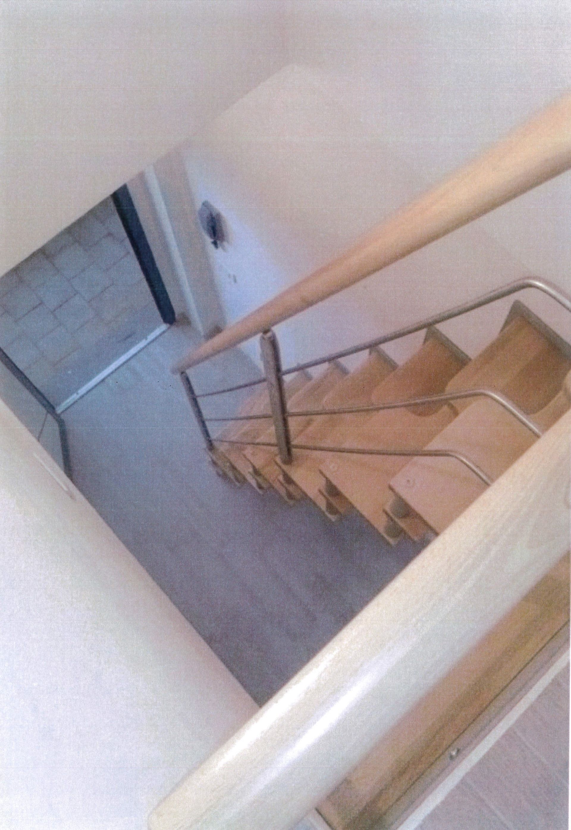 Una scala con ringhiera in legno e ringhiera in metallo