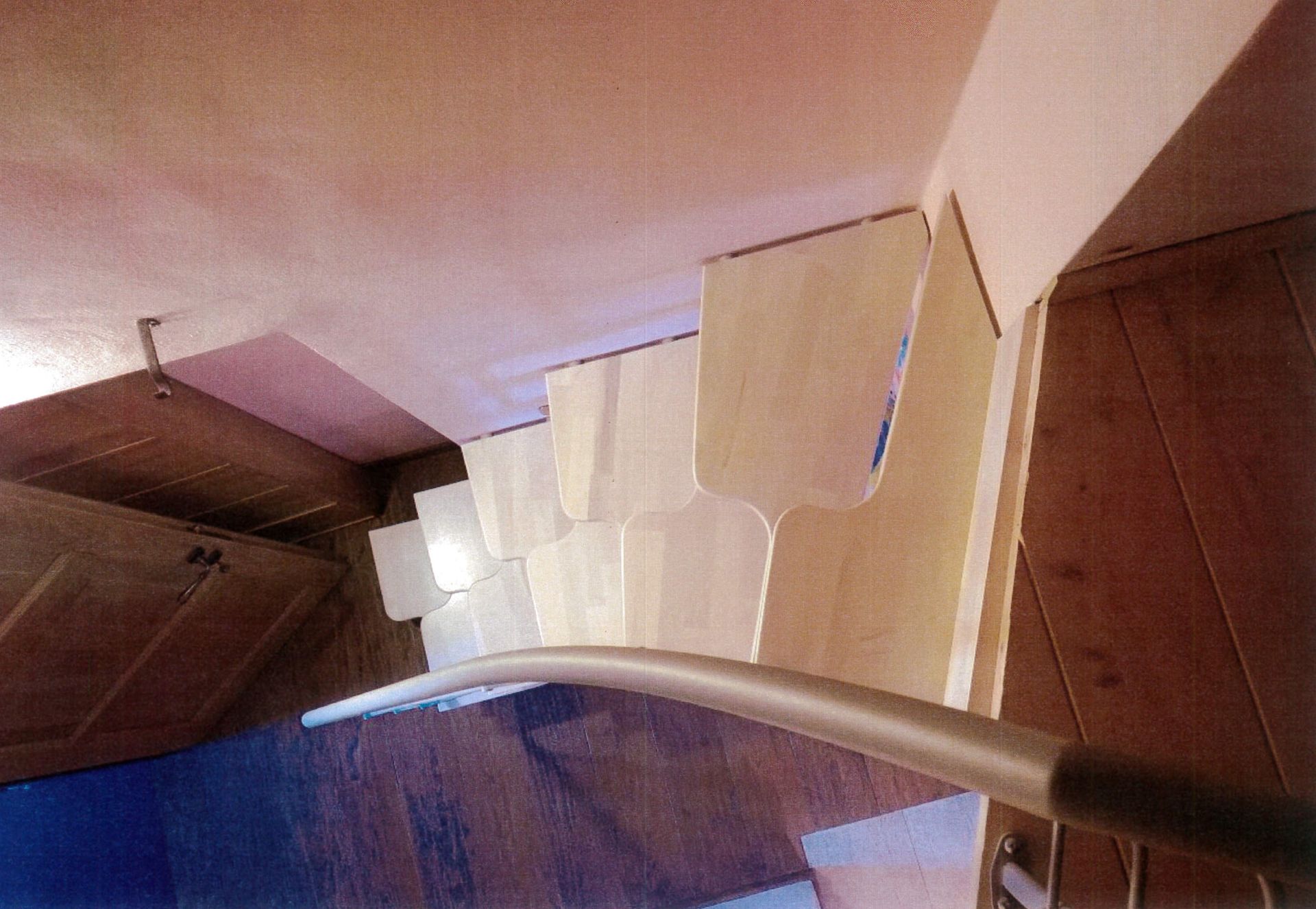 Una scala in legno con ringhiera in metallo e pavimento in legno