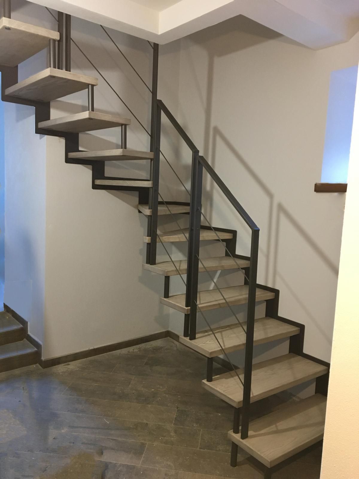 Una scala con una ringhiera di metallo in una stanza
