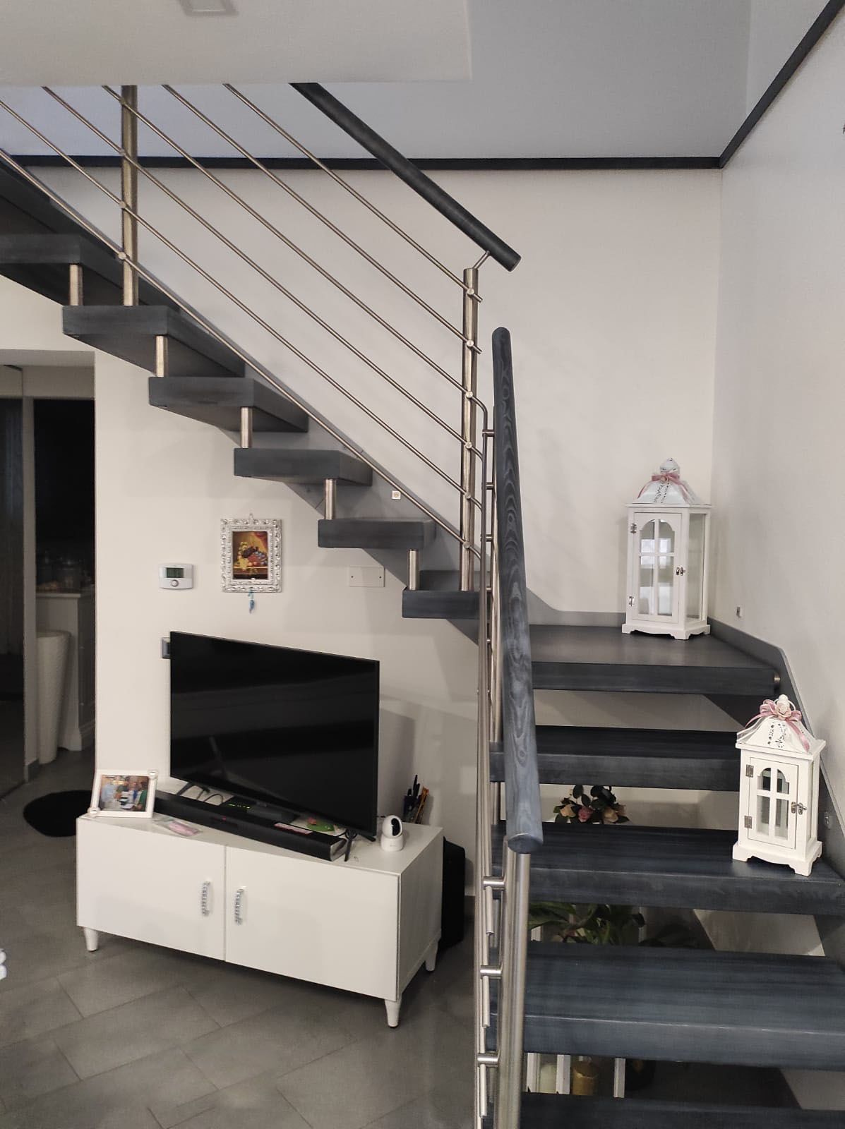 Un soggiorno con scale che portano al secondo piano