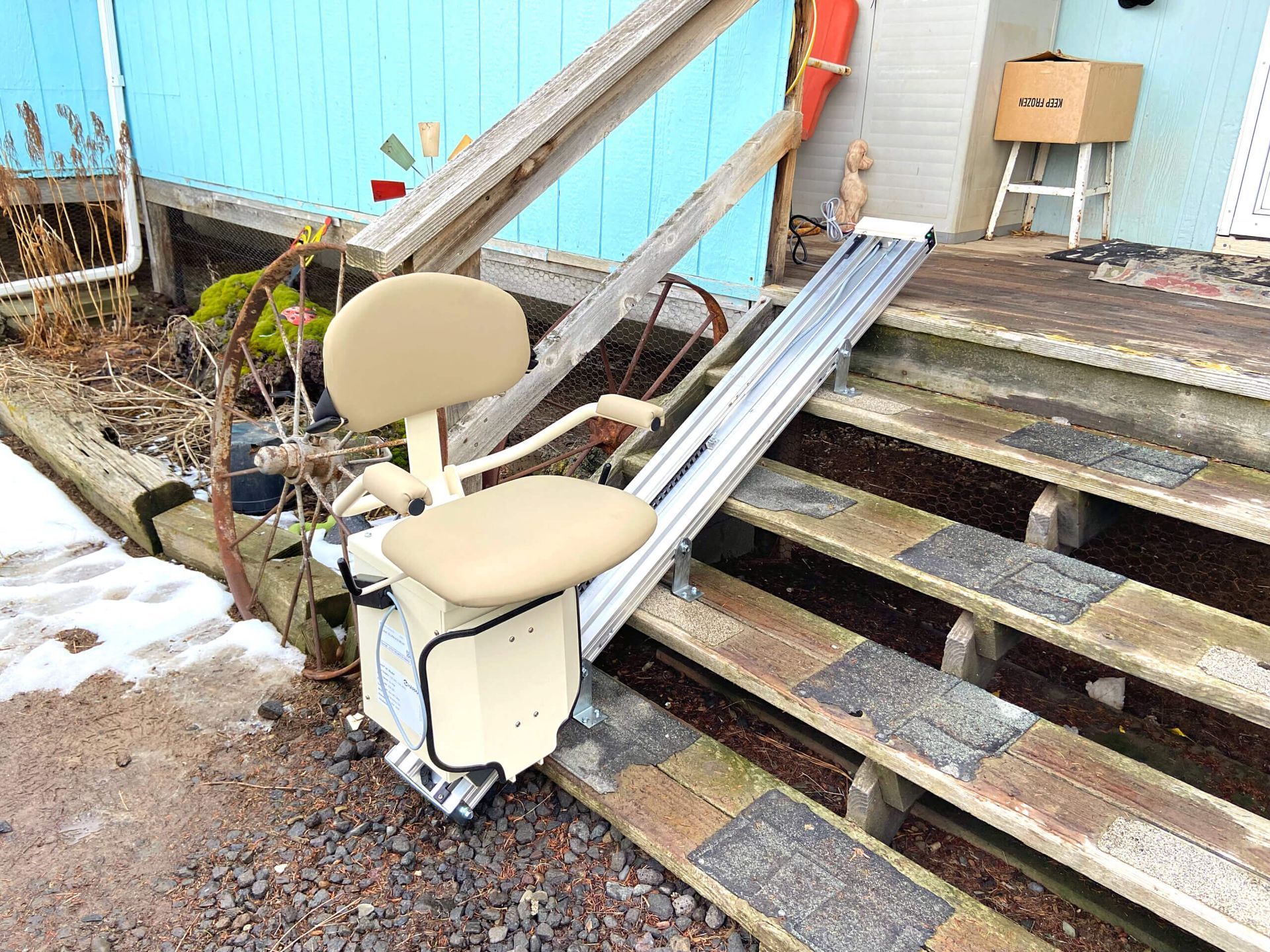 A chair lift is sitting on top of a set of wooden stairs.