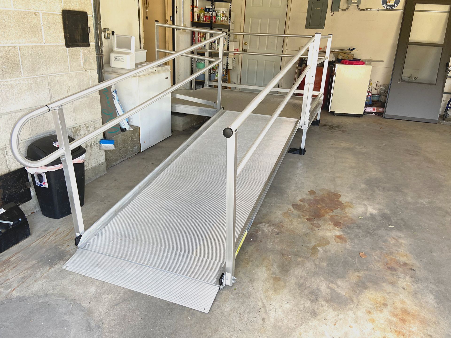 A ramp with a railing is in a garage.