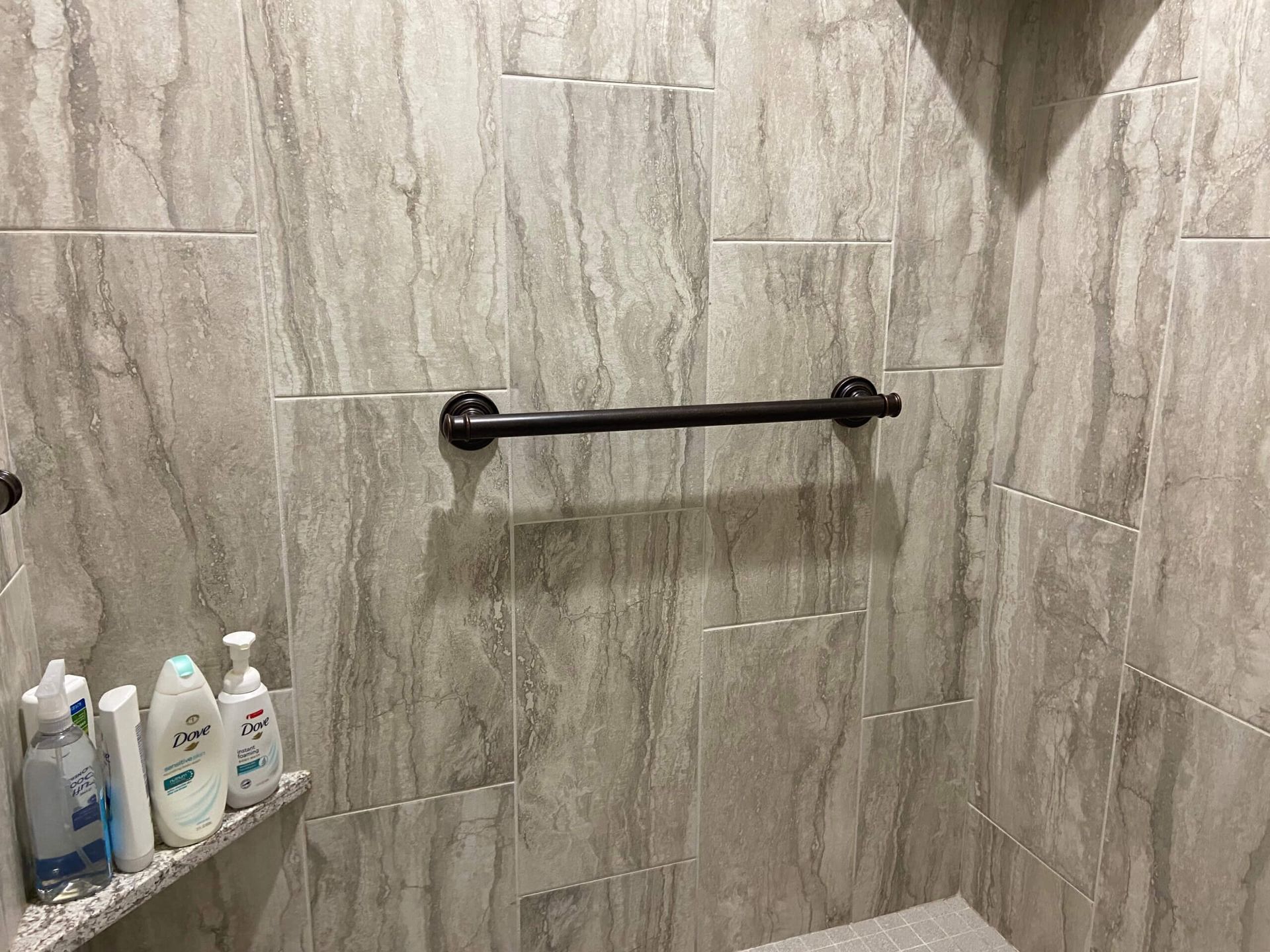 A bathroom with a walk in shower and a towel bar.