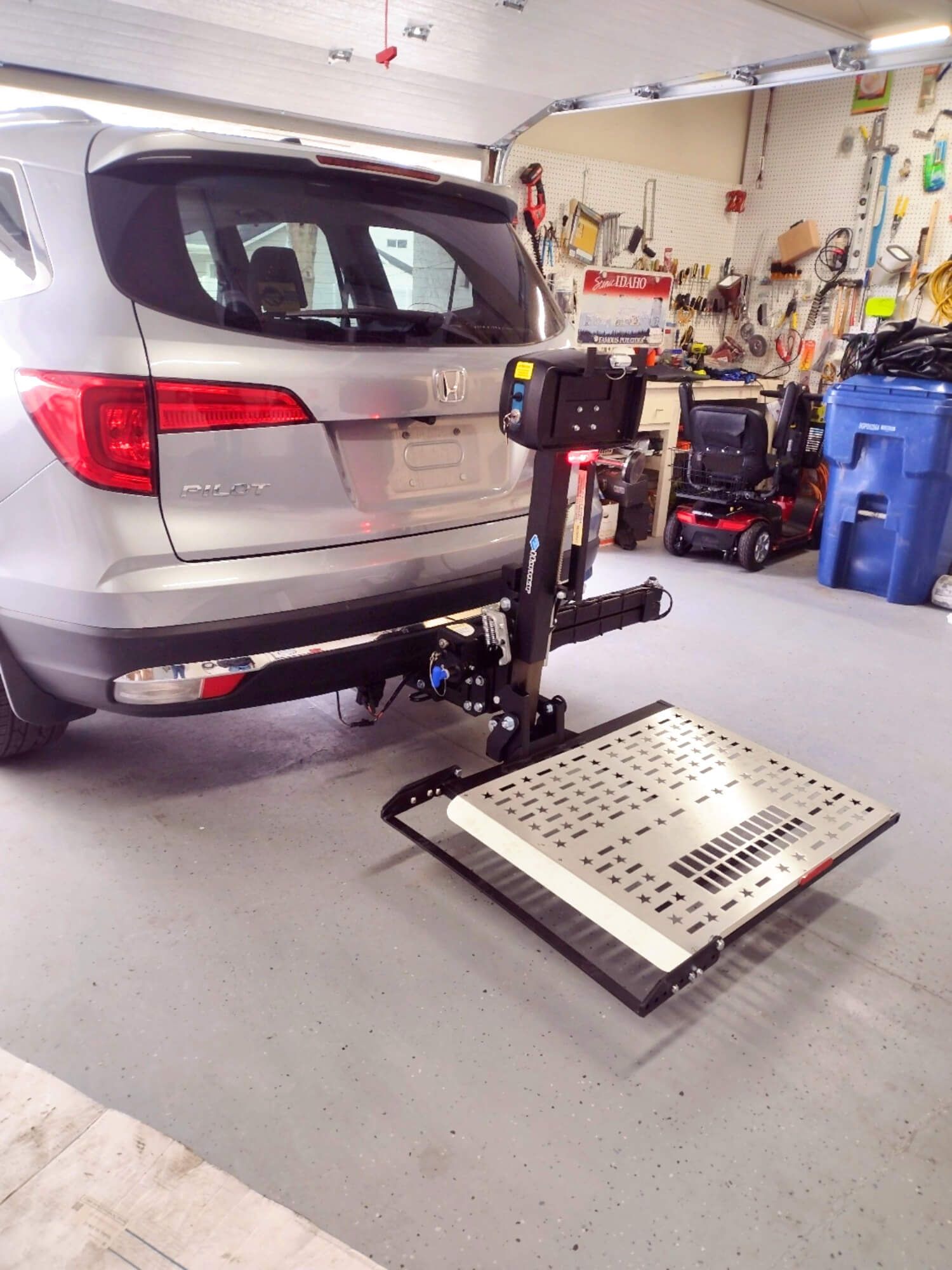 A car with a lift attached to it is parked in a garage.