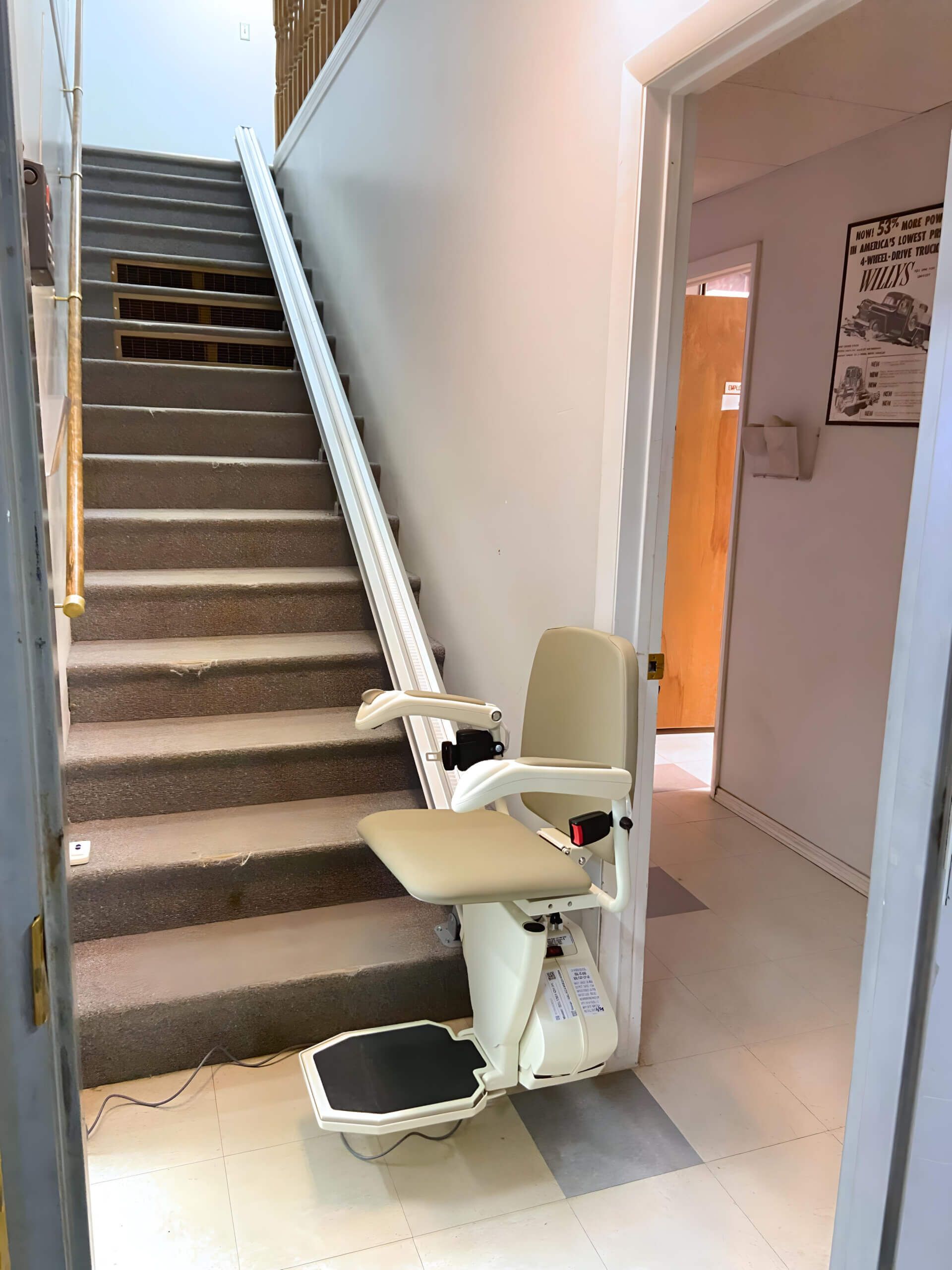 A stair lift is sitting next to a set of stairs.