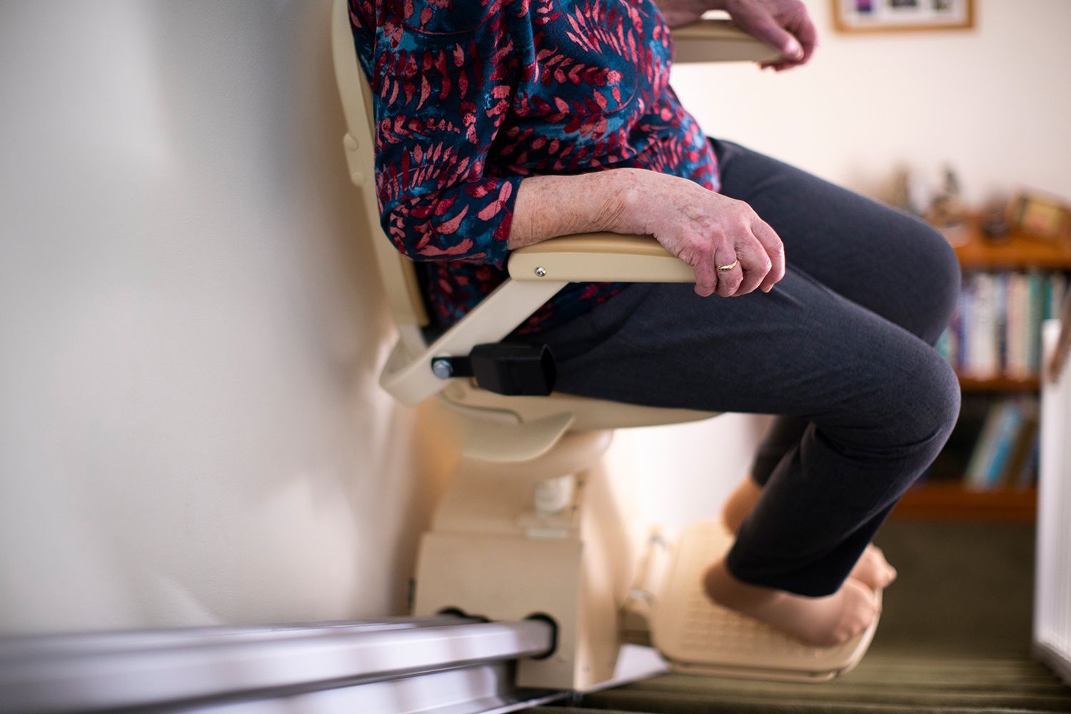Stairlift installed along a carpeted staircase in a home entryway.