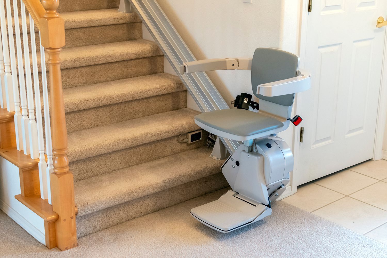 Stairlift installed along a carpeted staircase in a home entryway. Stairlift installed along a carpeted staircase in a home entryway.