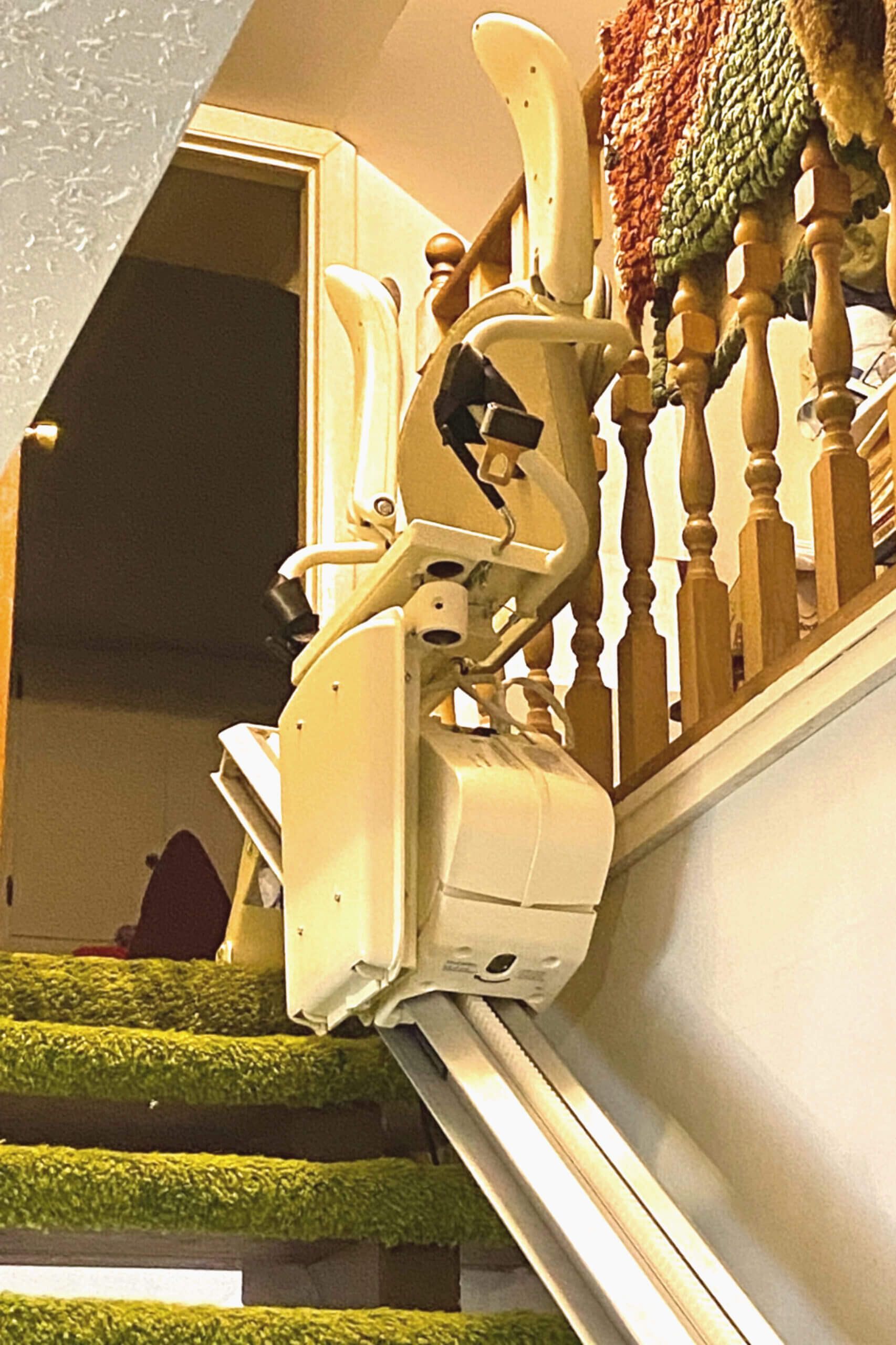 A stair lift is sitting on top of a set of stairs
