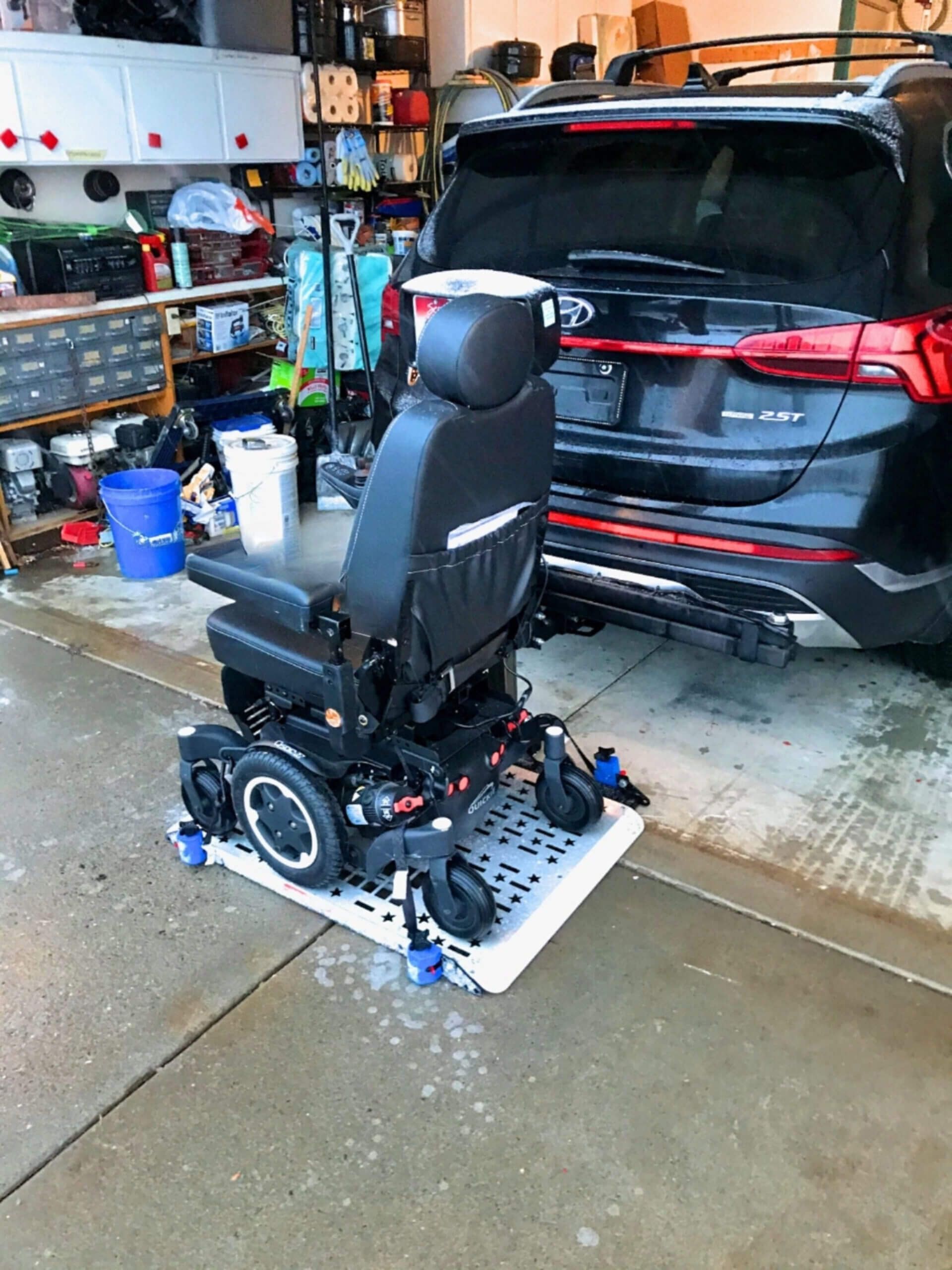 A mobility chair is sitting next to a car in a garage.