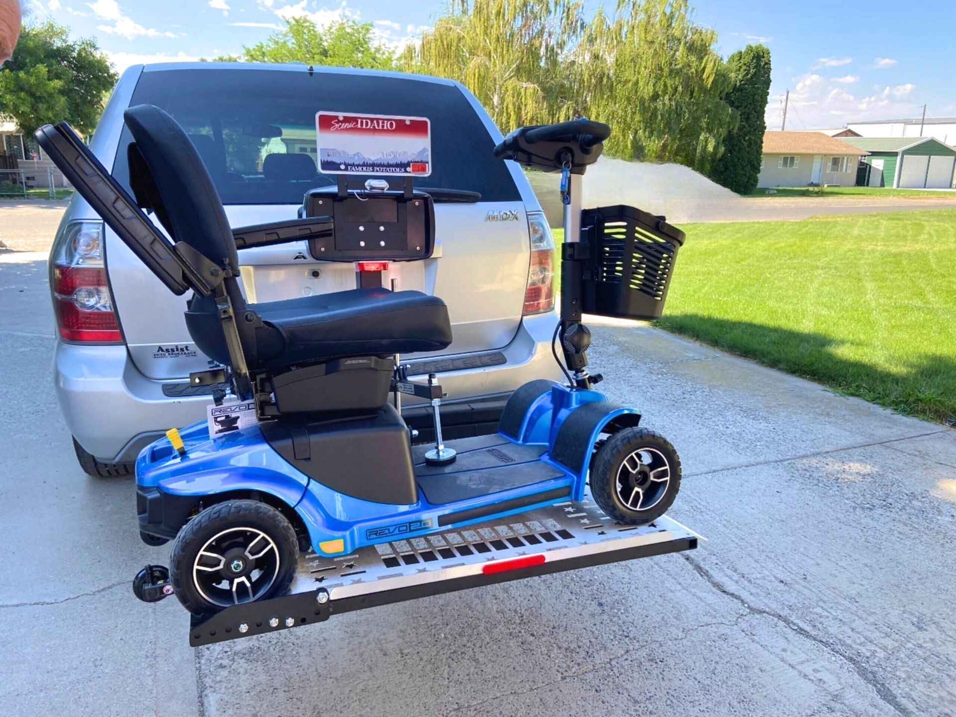 A blue mobility scooter is attached to the back of a car.
