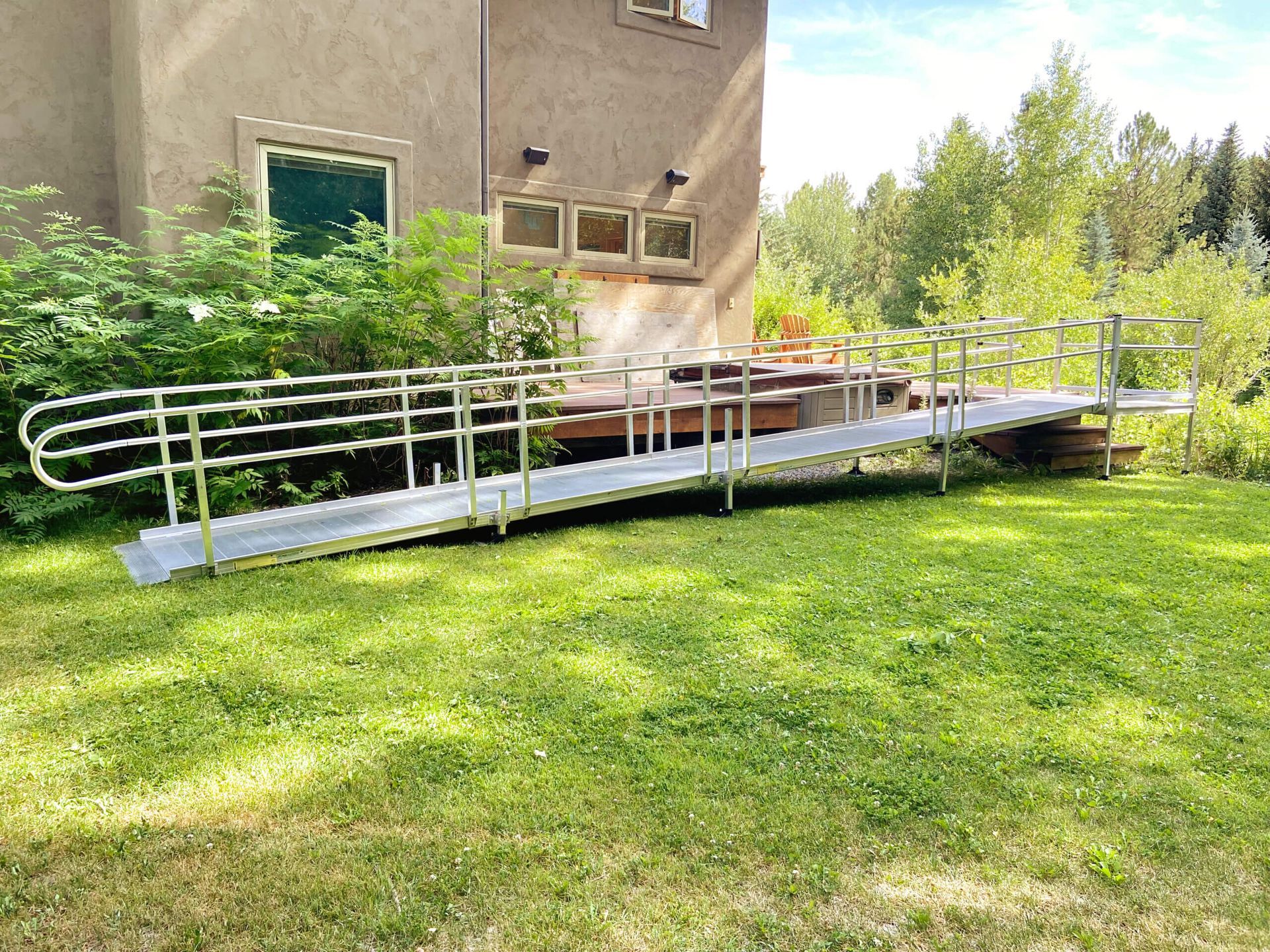 A wheelchair ramp is sitting in the grass in front of a house.