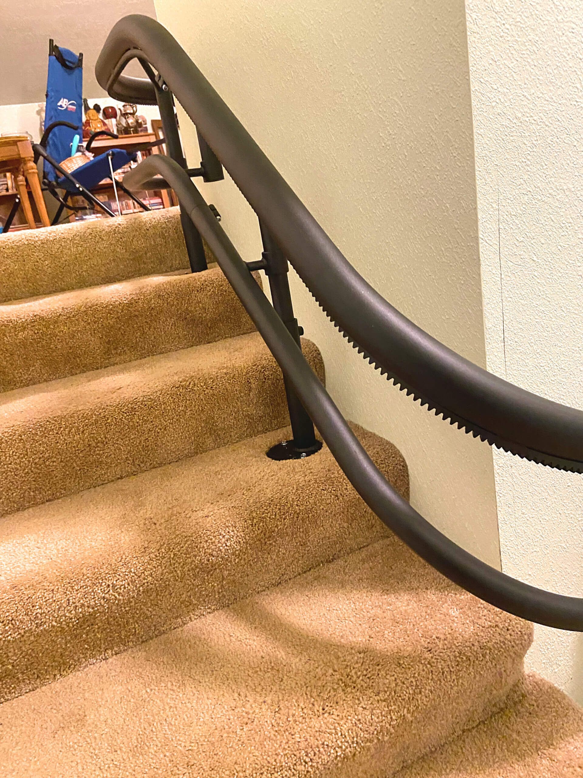 A staircase with a black railing and carpeted steps