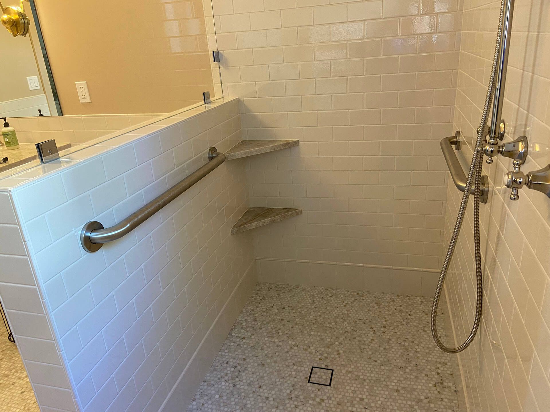 A bathroom with a walk in shower and a mirror.