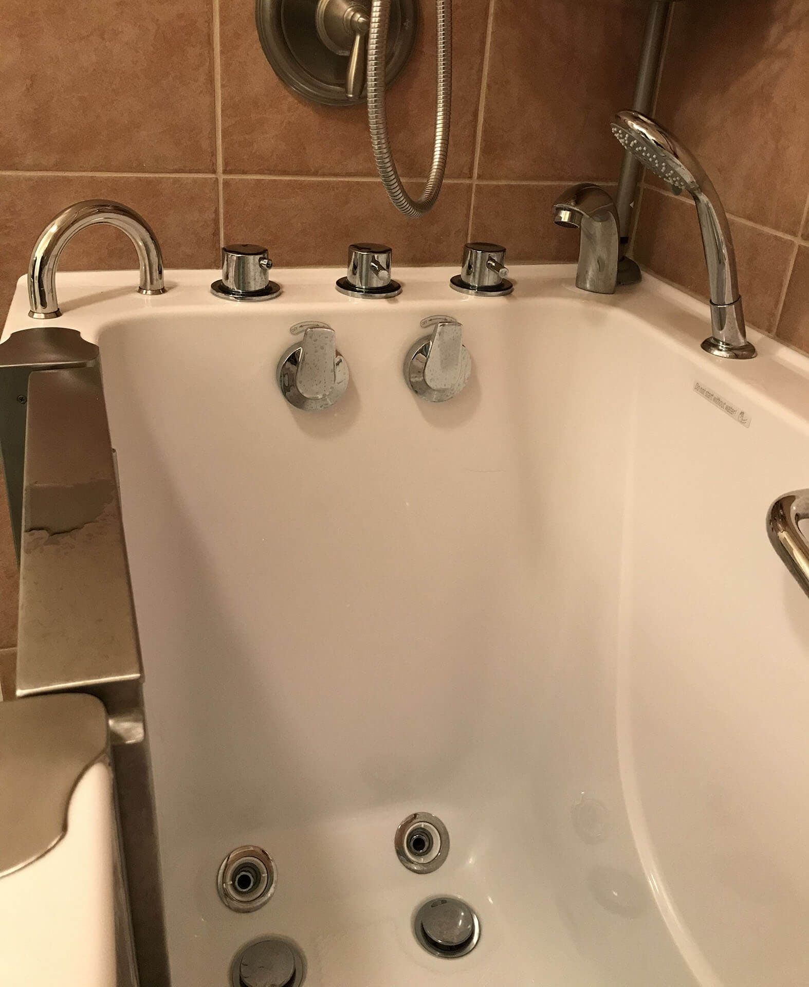 A white bathtub with chrome faucets in a bathroom