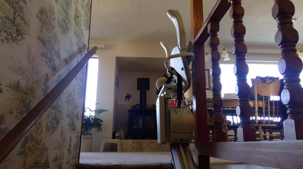 A staircase with a wooden railing leading up to a living room