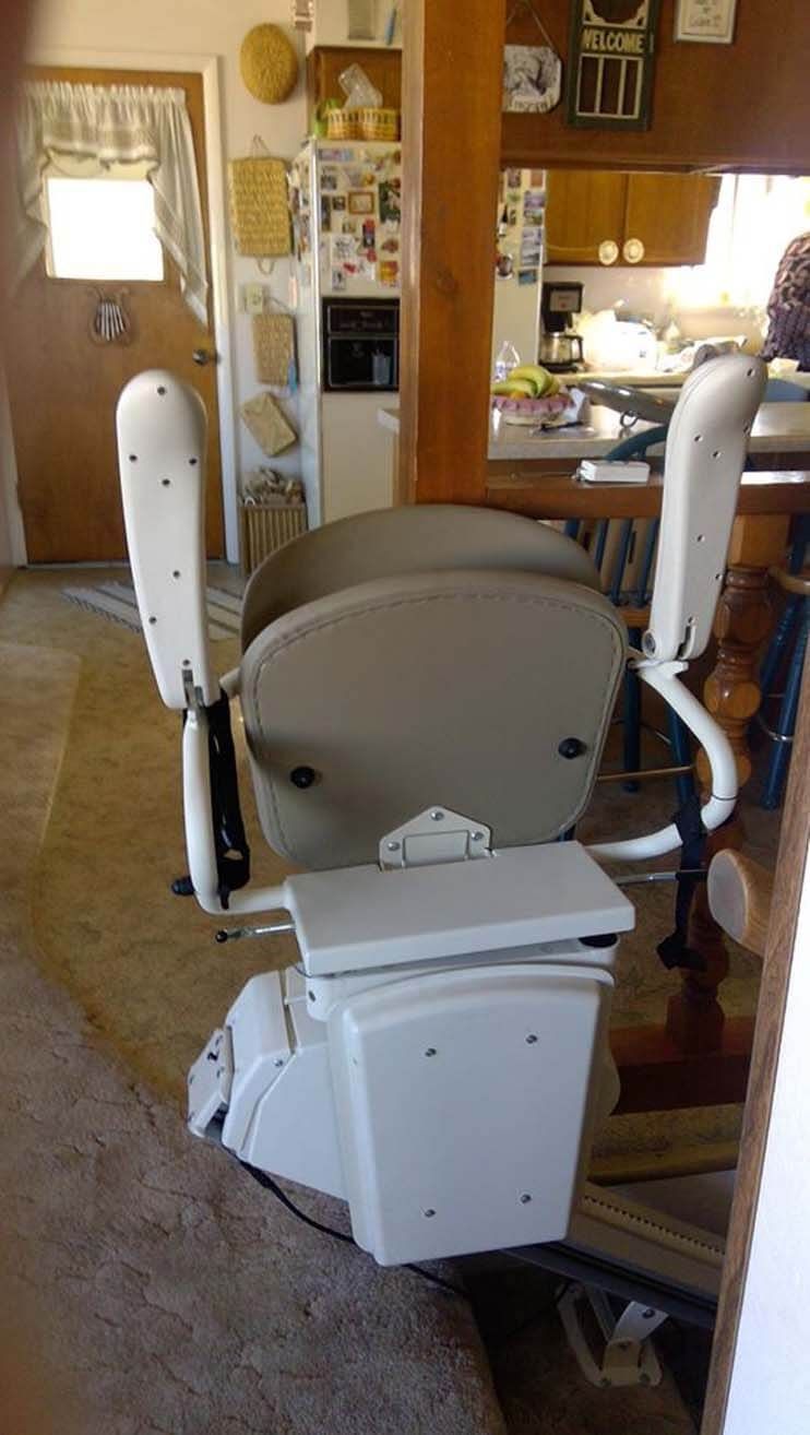 A stair lift is sitting on top of a staircase in a house.