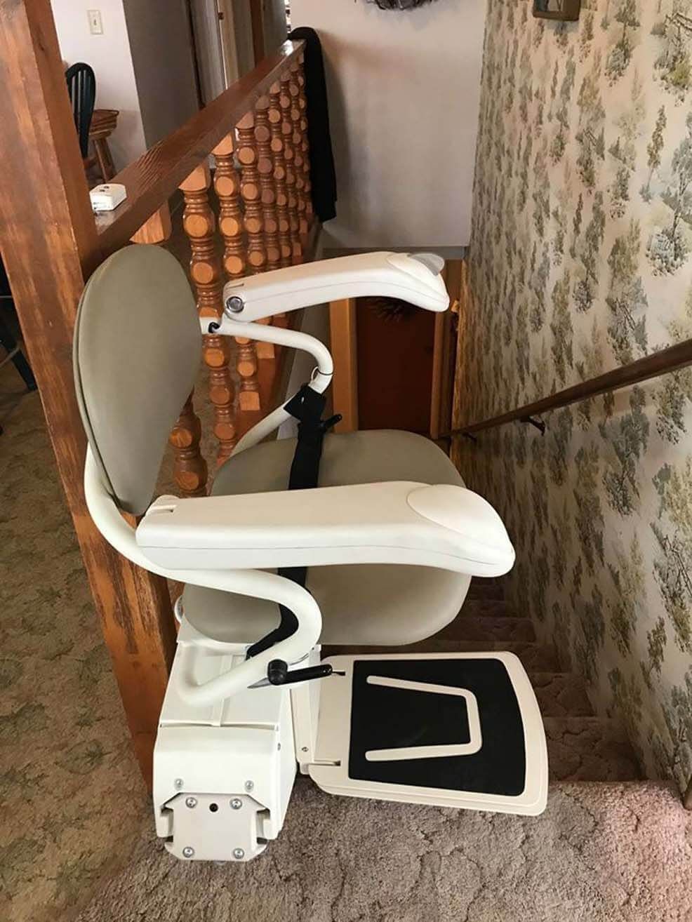 A white chair is sitting on top of a set of stairs.